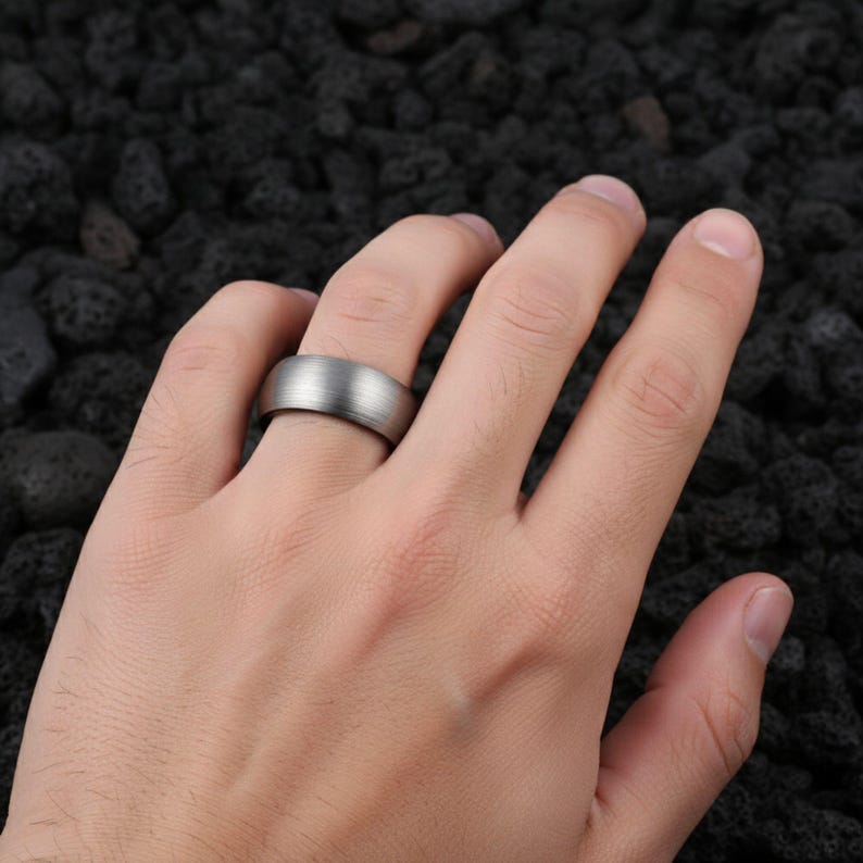 8mm brushed silver black tungsten carbide ring for men
Tungsten wedding band black interior comfort fit
Men's tungsten ring side view showing brushed finish
Custom engraved tungsten ring inner band
Man wearing black silver tungsten wedding band